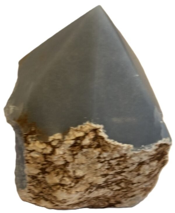 Natural rough angelite freeform with polished point 2 sians emporium Natural rough angelite freeform crystal with unpolished sides and a smooth polished blue point standing on a white background